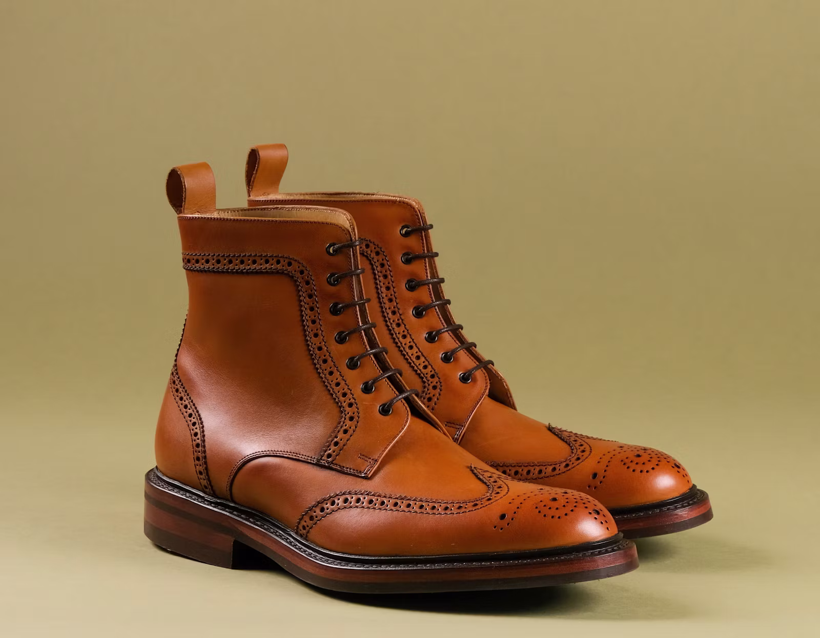 Pair of brown boots with tan background